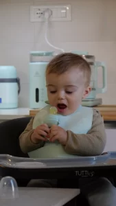 Bambino che utilizza un mangiafrutta in silicone 