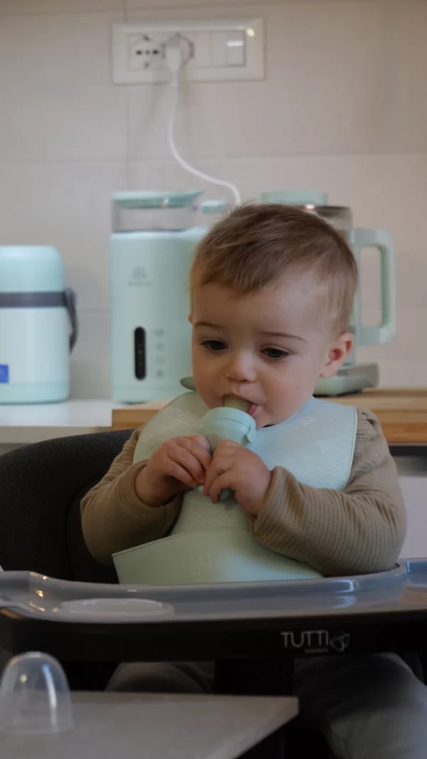 Bambino che usa un mangiafrutta in silicone